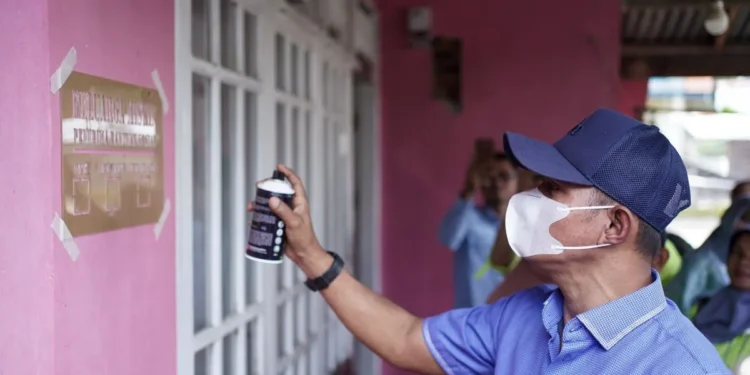 Bupati Solok Jon Firman Pandu saat pemasangan labelisasi di rumah keluarga penerima manfaat (KPM) bansos di Kabupaten Solok, Sumatera Barat. Diskominfo Solok.