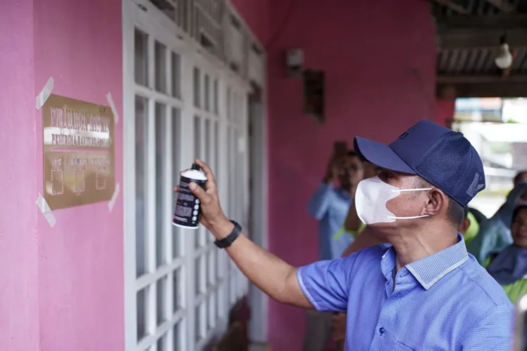 Bupati Solok Jon Firman Pandu saat pemasangan labelisasi di rumah keluarga penerima manfaat (KPM) bansos di Kabupaten Solok, Sumatera Barat. Diskominfo Solok.